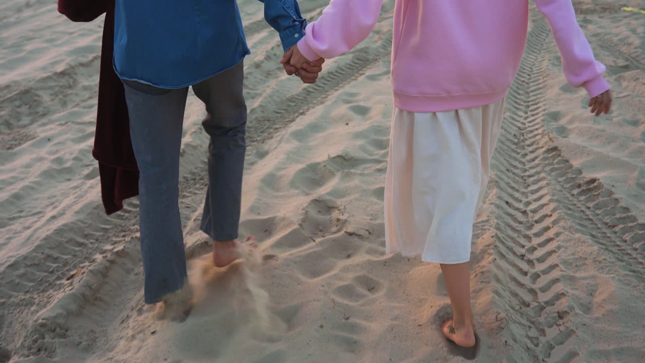 만적 인 커플 이 모래 에 안고 키스 하고 있다