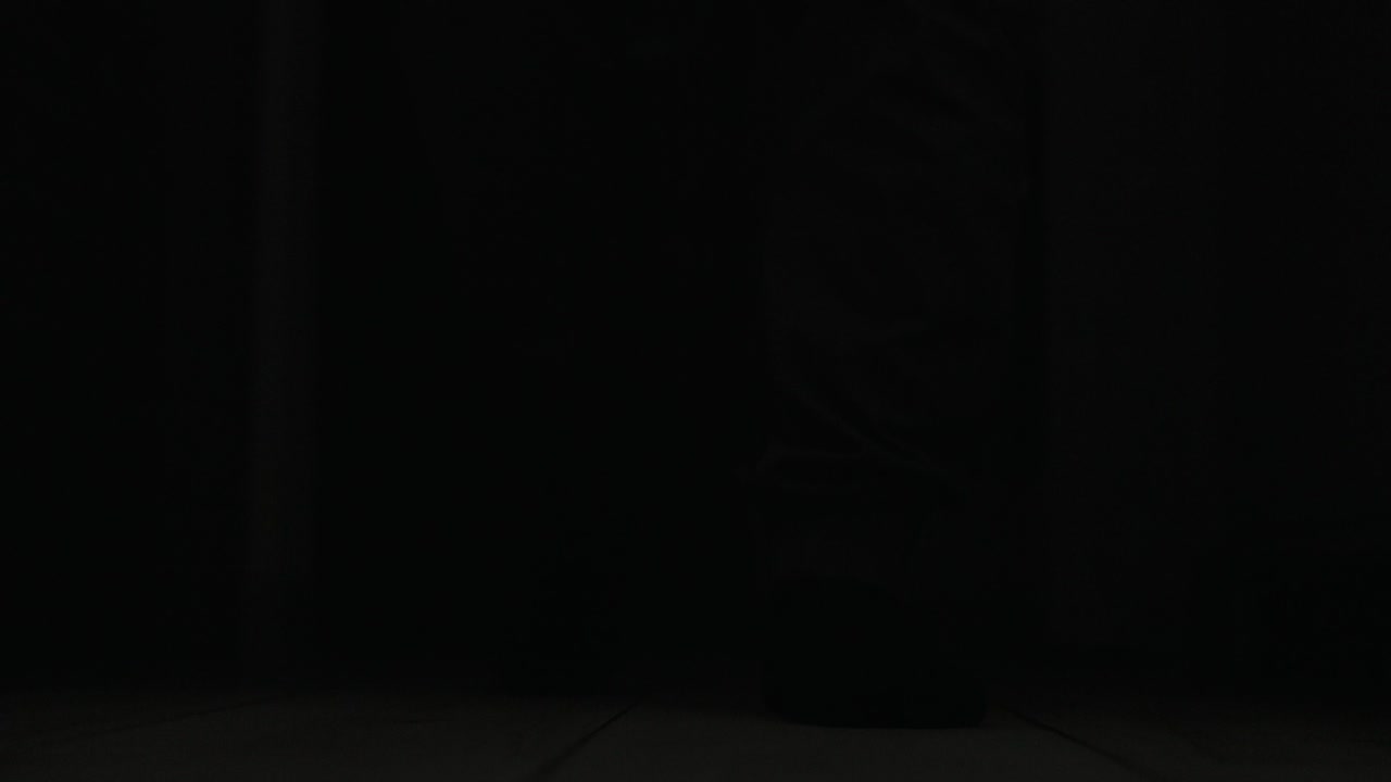 los pies de un hombre están explorando la casa oscura iluminada por el rayo - de cerca