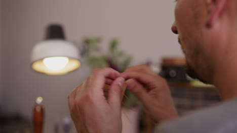 leathersmith sews detail with waxed thread in craft workshop