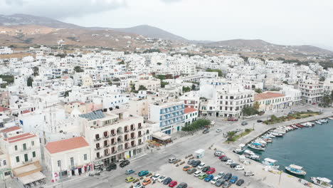 aerial drone flight towards the port of tinos in greece overlooking the city