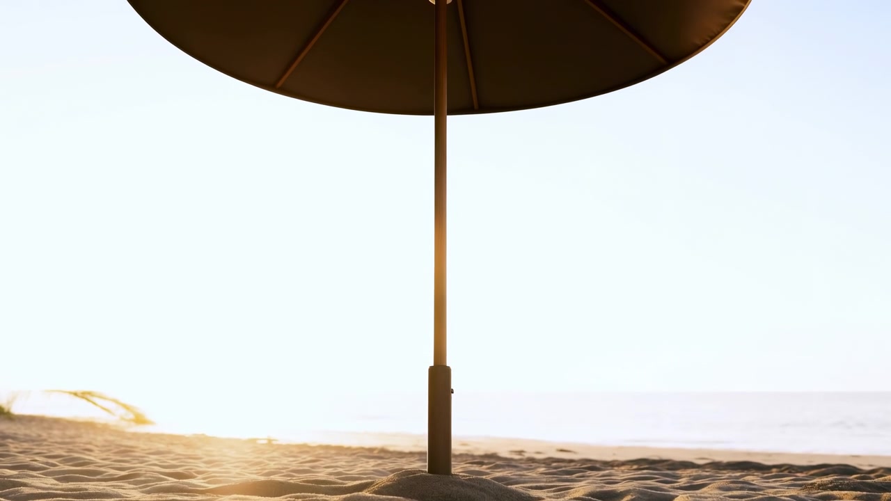 Ombrelloni da spiaggia fissi creano un'atmosfera rilassata e serena su una spiaggia sabbiosa sotto un cielo limpido, catturati in una ripresa grandangolare che evidenzia i materiali marroni e bianchi, in legno