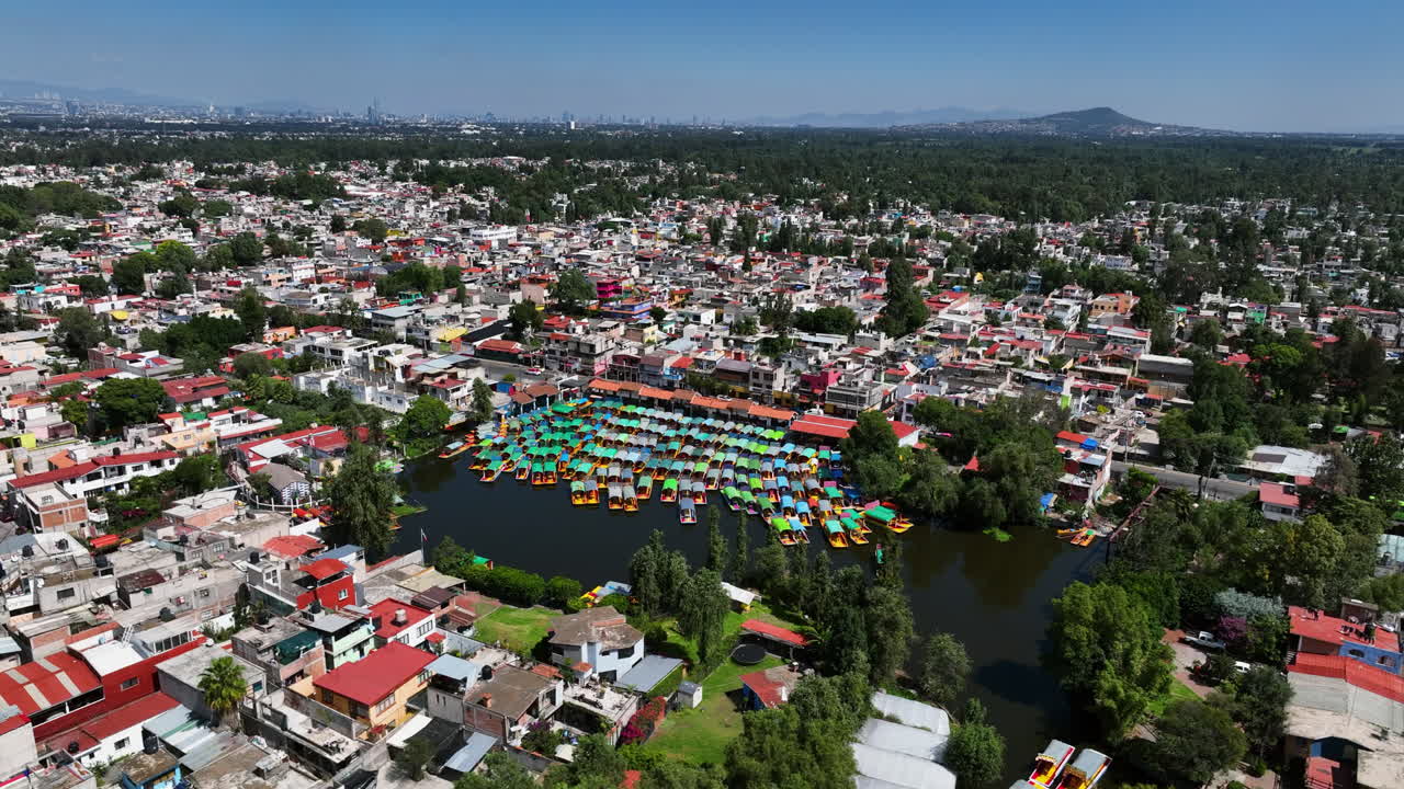 Panoramic drone shot of Trajinera boats moored in middle of a city in Mexico