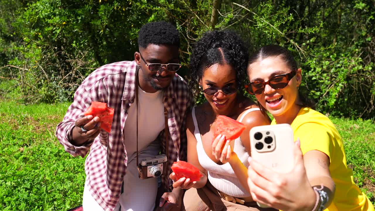 Friends enjoying watermelon at a picnic