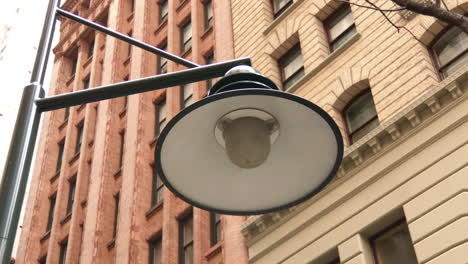 lámpara de la calle de la ciudad con edificios de piedra en segundo plano.