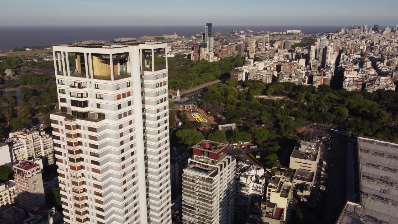 toma de órbita aérea de la torre de bloques residenciales en el suburbio de buenos aires - horizonte de fondo durante el día soleado