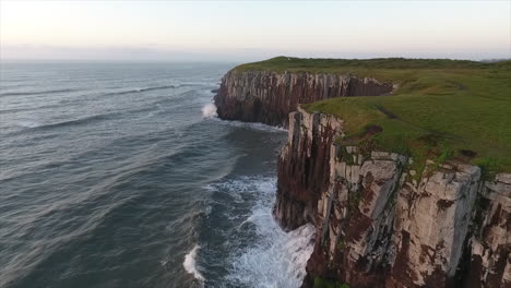 sonnenaufgang am meer und wellen, die in den felsen plätschern, luftaufnahmen, torres, brasilien