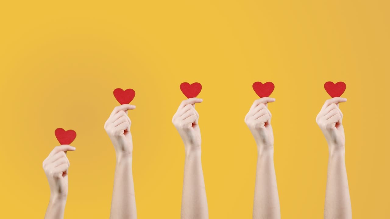 여성 블로거는 소셜 네트워크에서처럼 노란색 오렌지색 배경에 작은 빨간 심장을 손에 들고 있습니다. 발렌타인 데이, 국제 여성의 날, 사랑