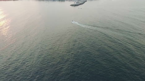 a yacht traveling to the shore at sunset