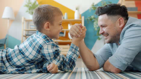 father and son arm wrestling at home