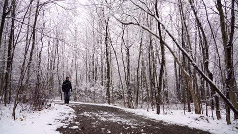 hombre caminando por un sendero con nieve