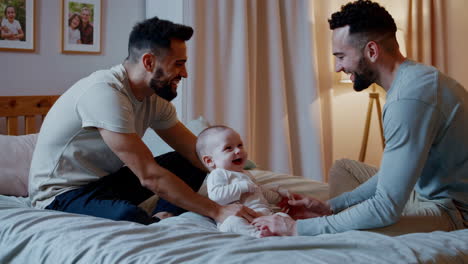two fathers bonding with their baby on the bed