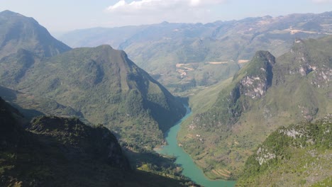 drone panning with twisty green nho que river between gigantic green karst mountain ranges running along ha giang viet nam