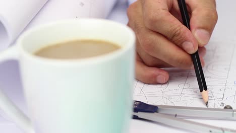 Architect-Working-Drawing-On-Project-With-Coffee