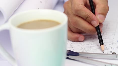 arquitecto trabajando dibujando en un proyecto con café