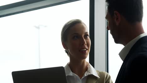 Businessman-and-woman-discussing-on-laptop