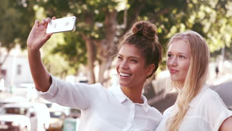 smiling attractive friends taking selfie