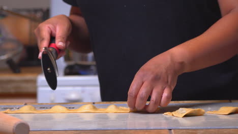 Homemade-ravioli-being-cut-into-individual-sections-with-a-pizza-slicer---static-isolated-view