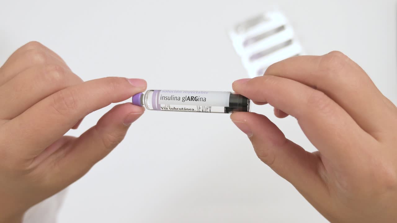 Physician showing an insulin glargine vial before injection on a white background