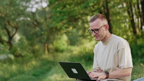 busy man working in the natural surroundings. freelancer looks at laptop sitting on the car.