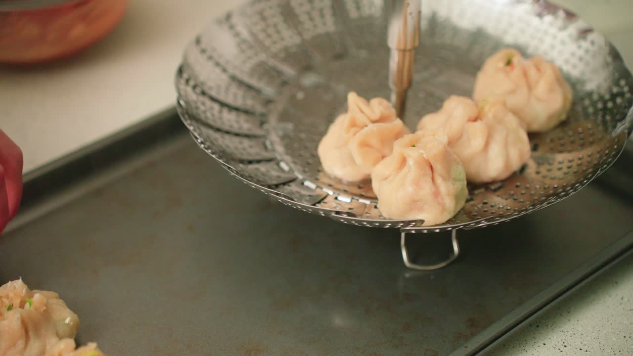 Taking freshly steamed dumplings off of the steamer