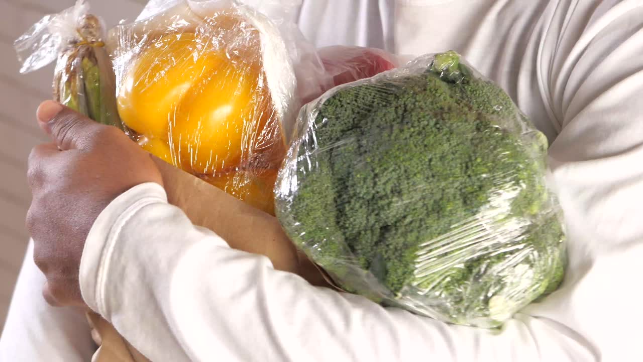 식료품 가방 을 들고 있는 사람