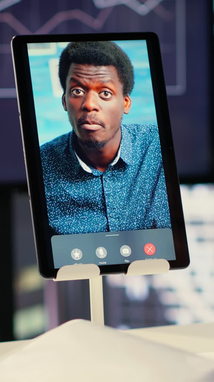 Uomo afroamericano in videochiamata tramite tablet in ufficio