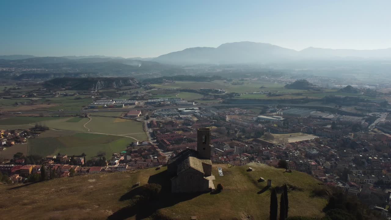 la ermita de tona domina la ciudad y el vasto valle bajo un cielo azul claro.