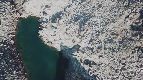 vista aérea superior de un lago alpino junto a montañas rocosas, cabane d&#39;orny, suiza, drone