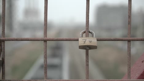 Lonely-lucky-lock-with-the-number-seven-on-an-industrial-bridge-while-the-train-goes-underneath