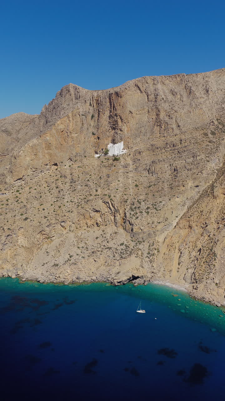 Vertical establish of Hozoviotissa Monastery perched on cliff in Amorgos, Greece, aerial drone approach