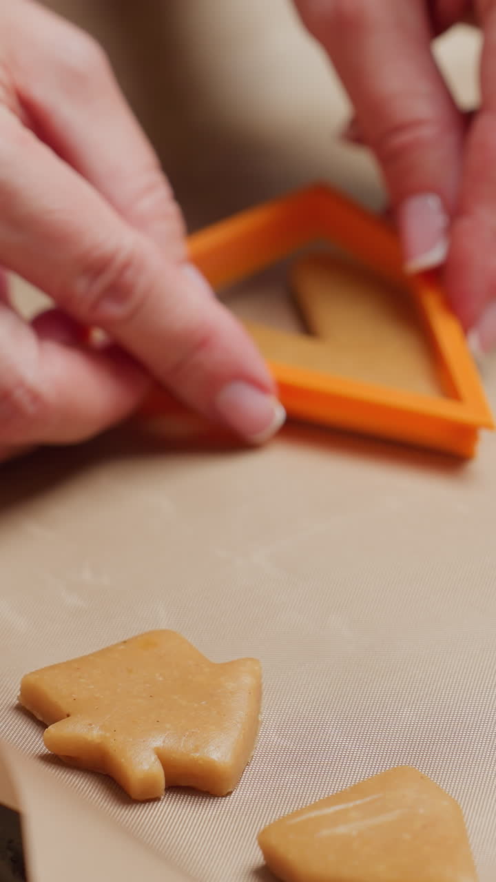 close-up of baker placing shaped cookie dough on parchment paper to bake, ready for oven, preparing cookies in cozy kitchen environment