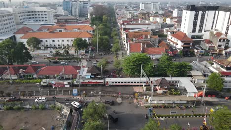 aerial view of a city with a train passing through a busy intersection