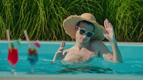 hombre disfrutando de bebidas junto a la piscina