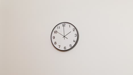 a minimalist office clock hanging on a white wall, showing the time as 2:00 in a clean and professional setting.