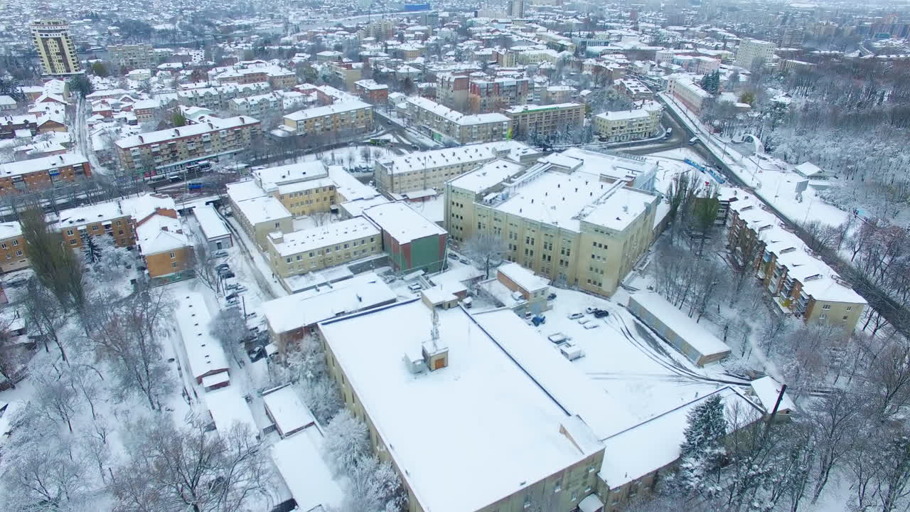 Beautiful view of the busy city on winter season. Building tops are covered with snow. Aerial perspective.