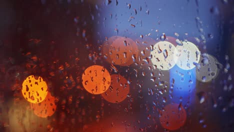 luces de la ciudad fuera de foco por la noche vistas a través de una ventana cubierta de gotas de lluvia durante la lluvia. macro de cerca.