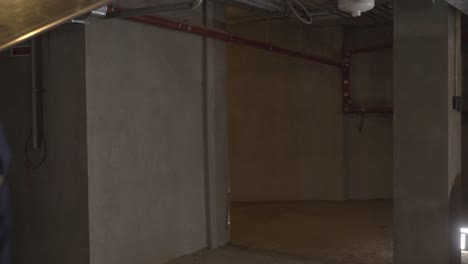 construction worker carrying a metal duct in a basement