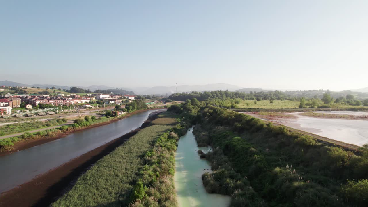 Fiume tranquillo tra la vasta natura e un piccolo villaggio spagnolo nella provincia della Cantabria in una calda giornata estiva.