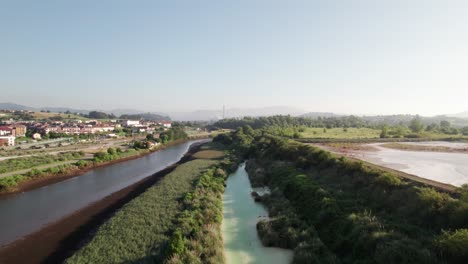 Calm-river-between-the-vast-nature-and-small-Spanish-village-in-the-province-of-Catabria-on-a-warm-summer-day
