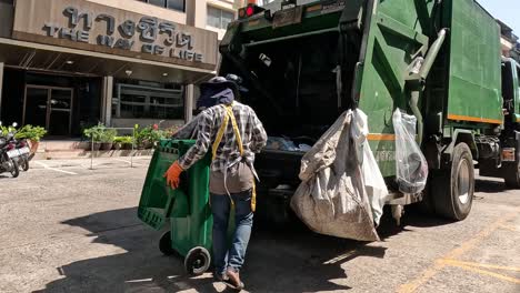 workers loading trash into a garbage truck