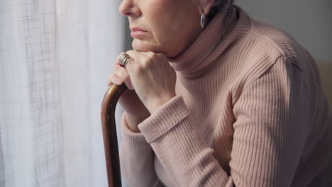 Thinking,-window-and-hands-of-old-woman