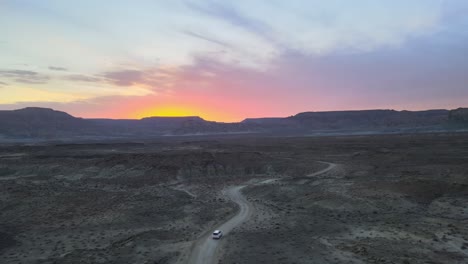 Drone-flies-over-a-car-driving-thru-Smoky-Mountain-towards-Alstrom-Point,-Lake-Powell