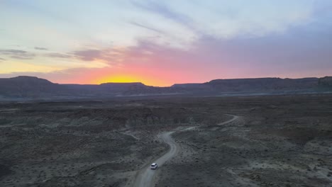 drone flies over a car driving thru smoky mountain towards alstrom point, lake powell