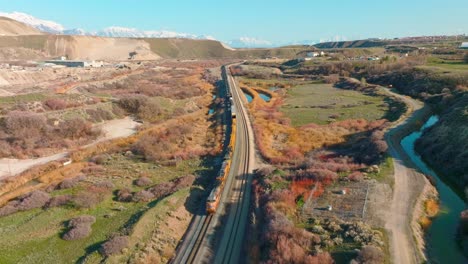 aerial - train on railroad tracks close to bluffdale, utah, forward lowering shot