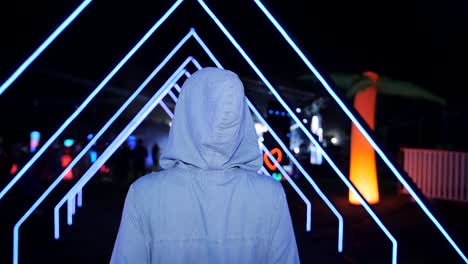 girl goes on a slumber party under the open sky. festival dance party outdoors. neon lights and laser beams.