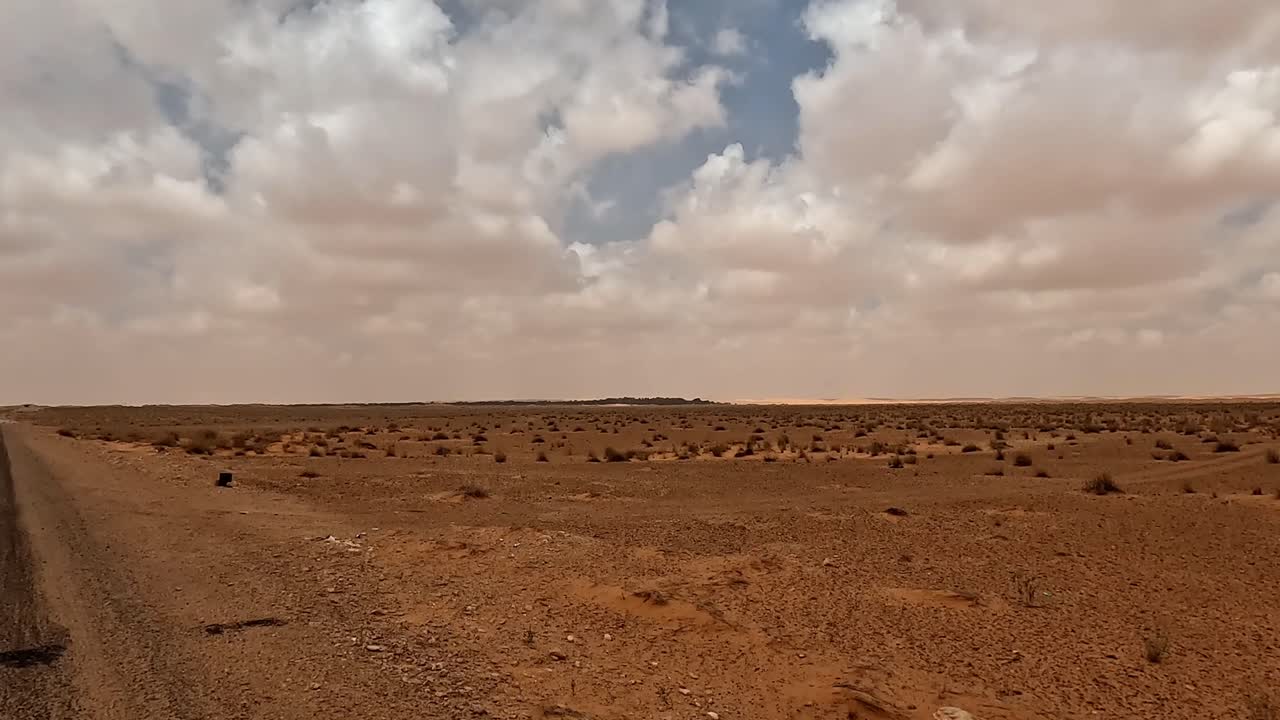 conduciendo por un camino recto a través del paisaje desértico de túnez