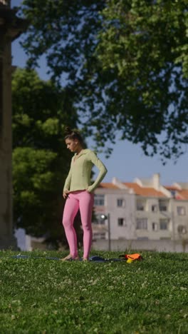 young woman practicing yoga in a park