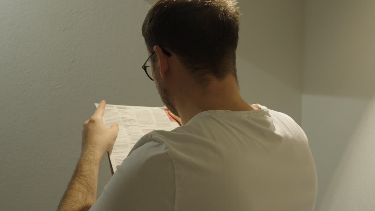 A man looks for job offers in a newspaper, representing unemployment, job search, and career opportunities