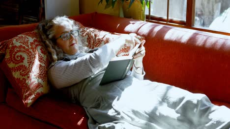 Mature-woman-reading-a-book-in-living-room-4k