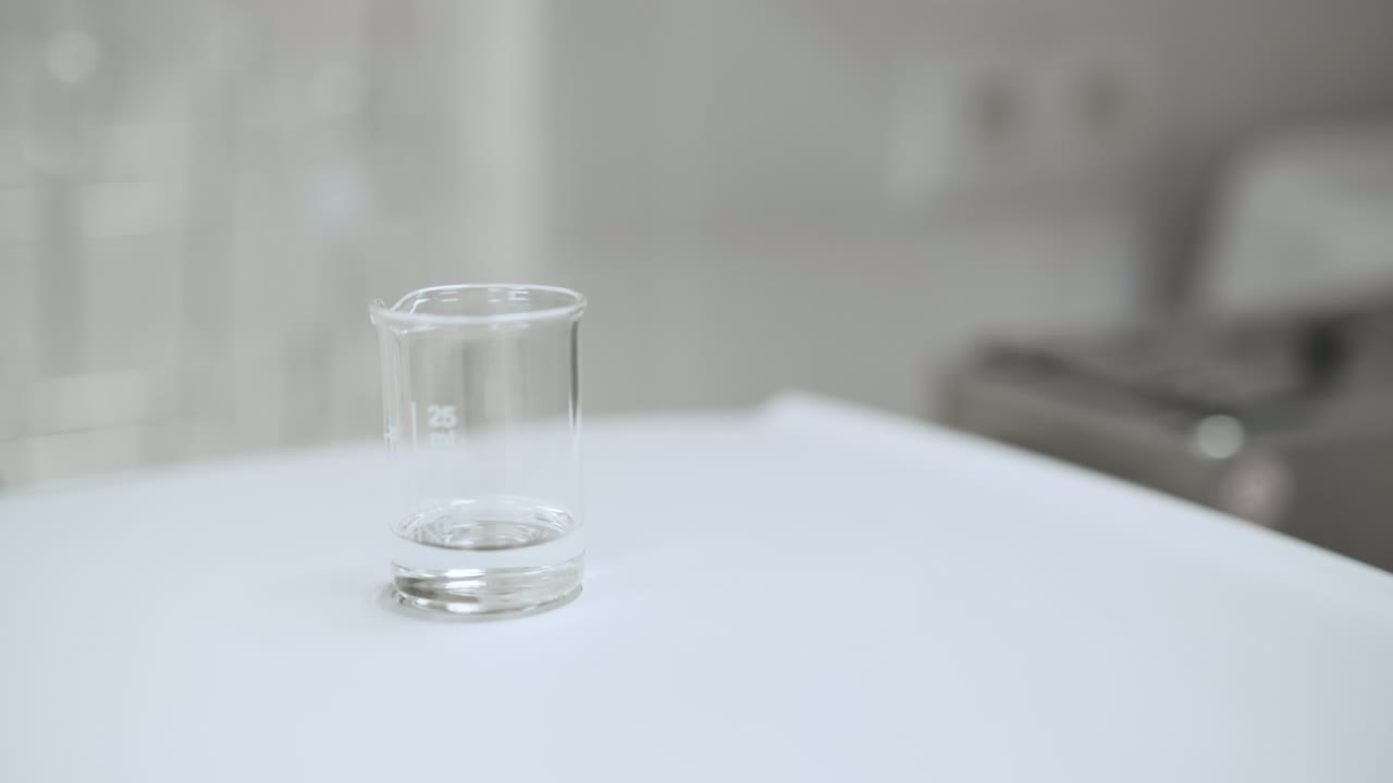 Close up laboratory woker filling the bealer with solvent from the wash bottle